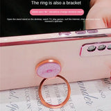 someone is holding a ring on a cell phone with a pink background