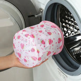 a person holding a pink hat in front of a washing machine