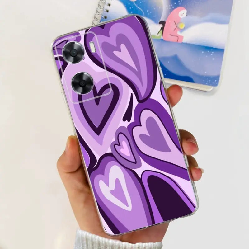 a person holding a phone case with a purple heart design