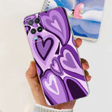 a person holding a purple phone case with a heart design