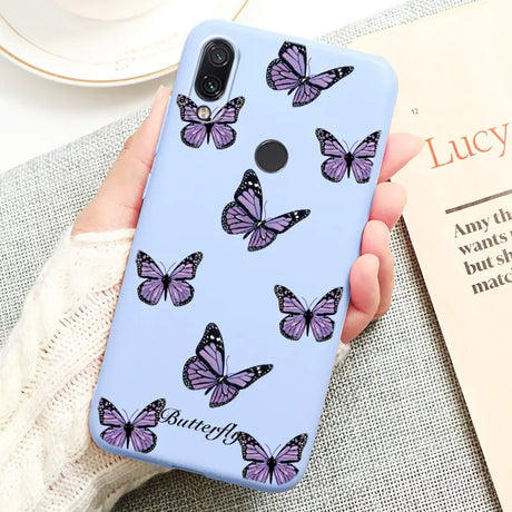 a woman holding a phone case with butterflies on it