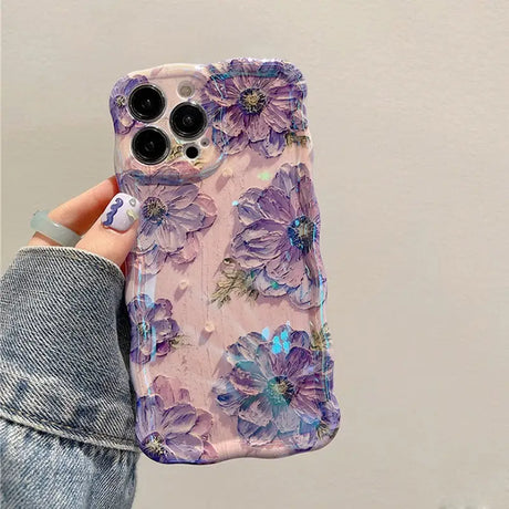 a woman holding a phone case with purple flowers on it