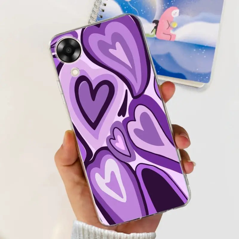a hand holding a purple phone case with hearts on it