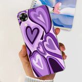 a hand holding a purple phone case with hearts on it