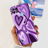 a person holding a purple phone case with a heart design
