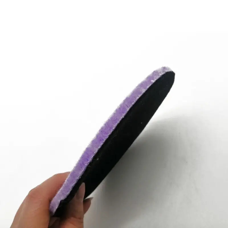 a hand holding a purple sponge