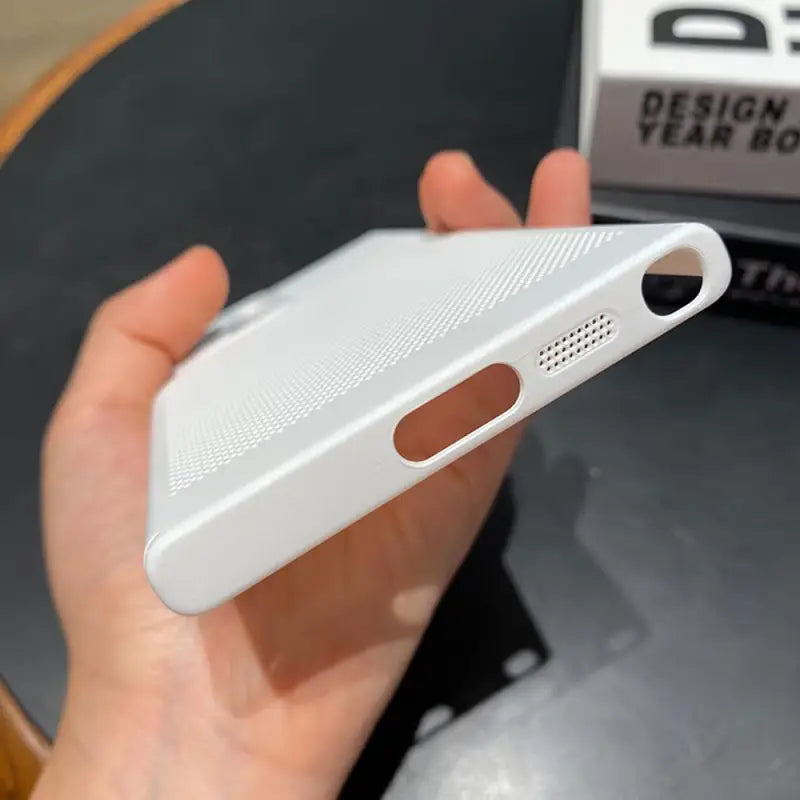 a hand holding a white iphone case