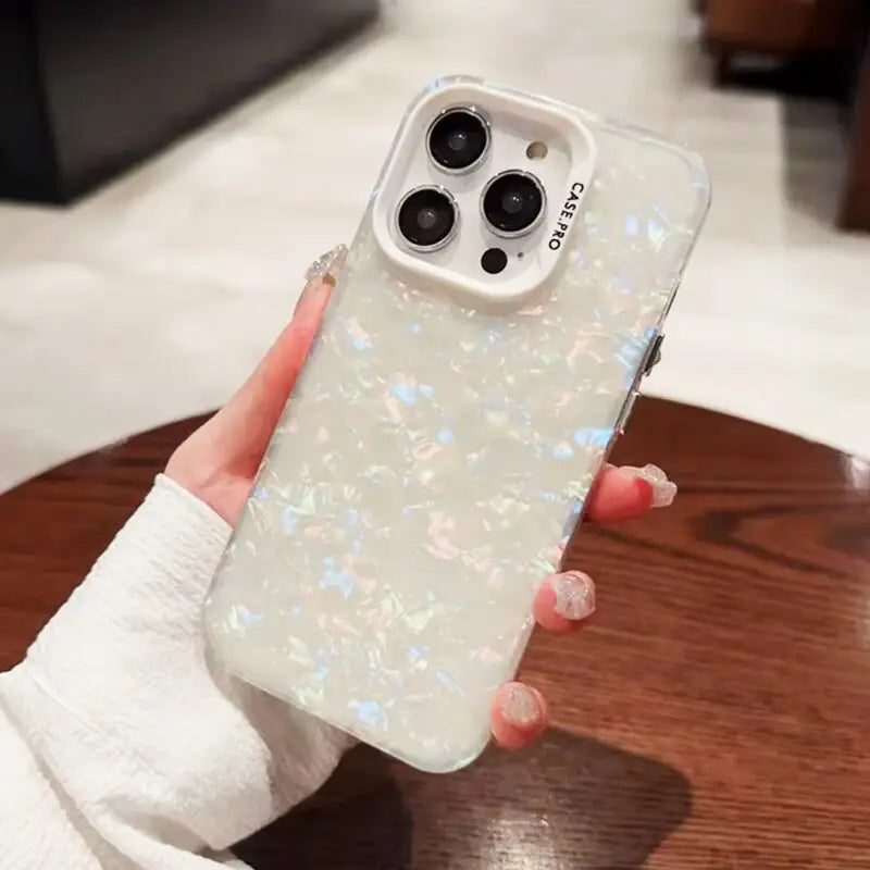 a woman holding a phone case with a white glitter effect