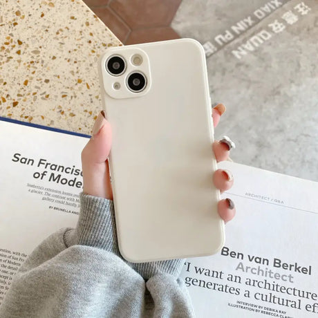 a person holding a white iphone case