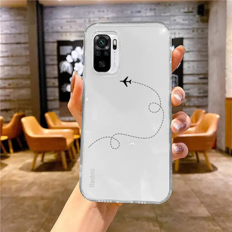 a hand holding a white iphone case with a plane drawn on it
