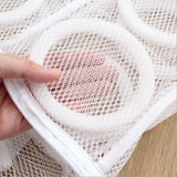 a person holding a white mesh bag with a pink heart on it
