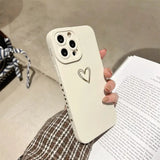 a person holding a white phone case with a heart drawn on it