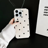 a person holding a white phone case with black dots