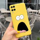 a person holding up a yellow phone case with a face