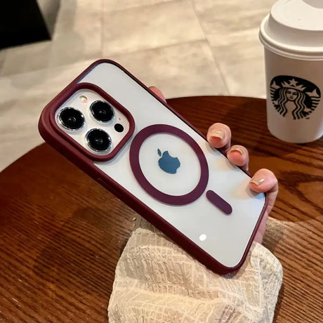 A person holding an iphone case with a coffee cup in the background