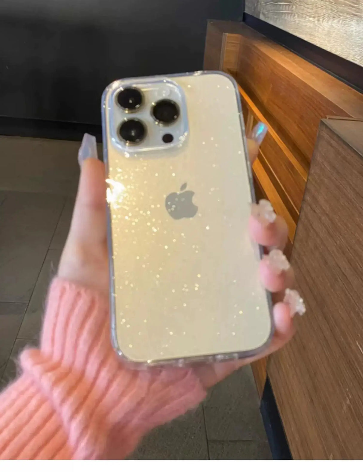 a person holding an iphone case with glitter