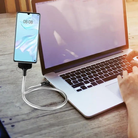 a person using a laptop with a charging cable