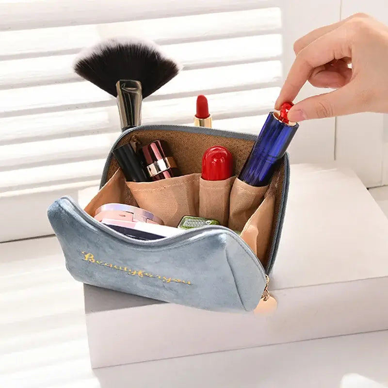 a person putting makeup brush in a bag