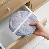 a person opening a drawer with a mesh cover