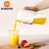 A person pouring orange juice into a glass