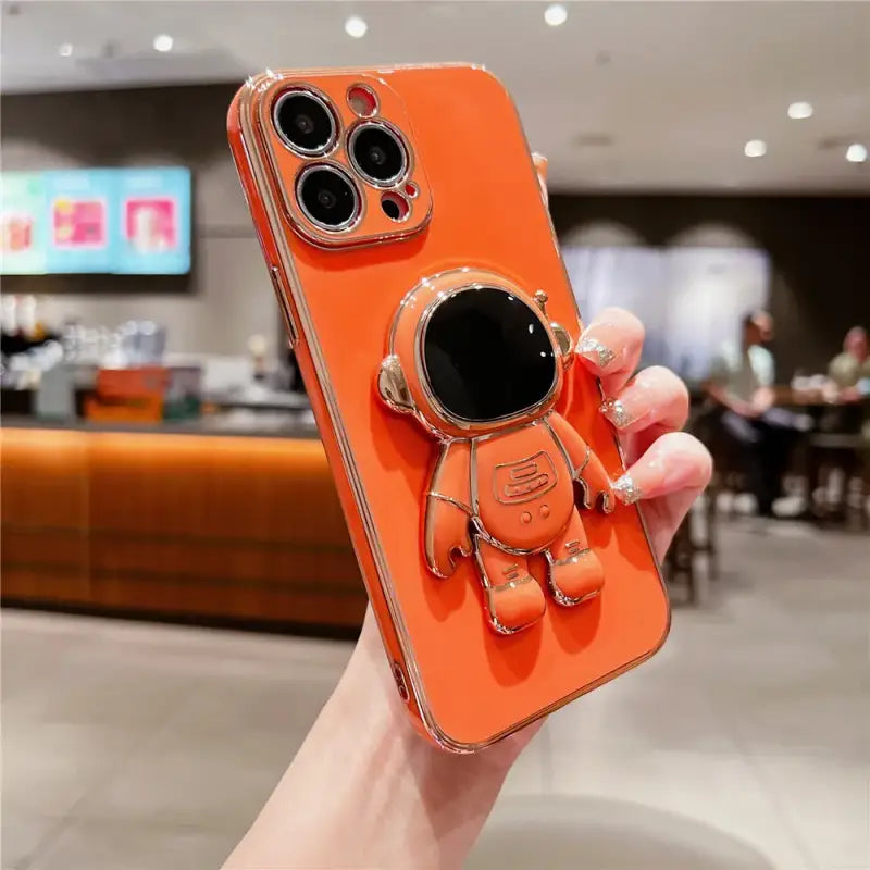 a person holding an orange phone case with a camera