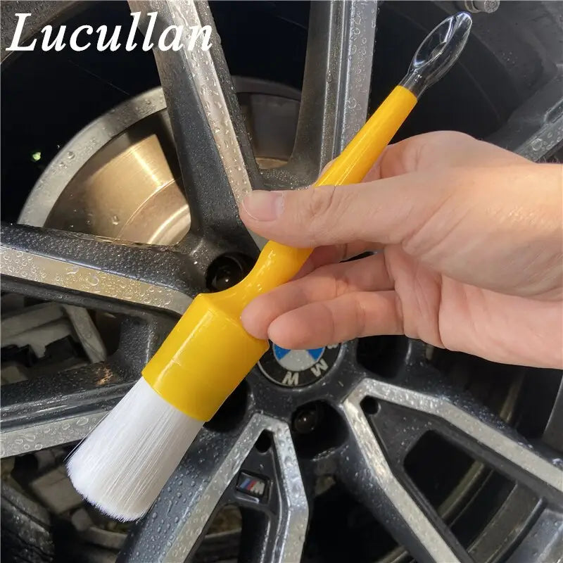 a person is painting a wheel with a brush