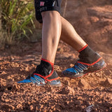 a person wearing a pair of shoes and running through a dirt