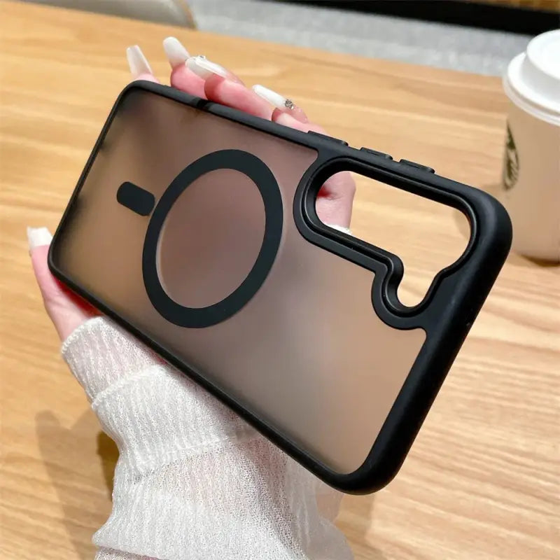 a person holding a phone with a black case