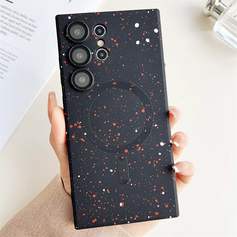 A person holding a phone case with a black and red galaxy pattern