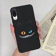a person holding a phone case with a black cat face