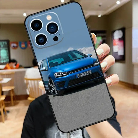 A person holding a phone case with a blue volkswagen car