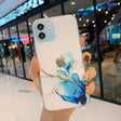 A person holding a phone case with a blue and white marble design