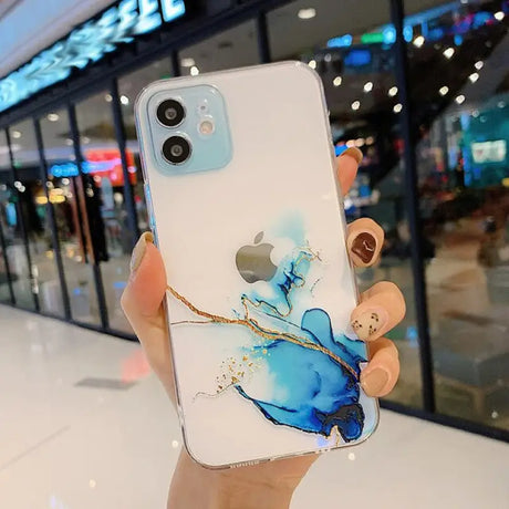 A person holding a phone case with a blue and white marble design