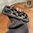 A person holding a phone case with a camouflage print