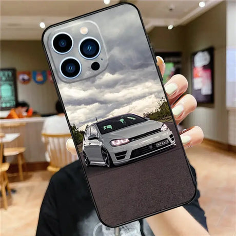 A person holding up a phone case with a car on it