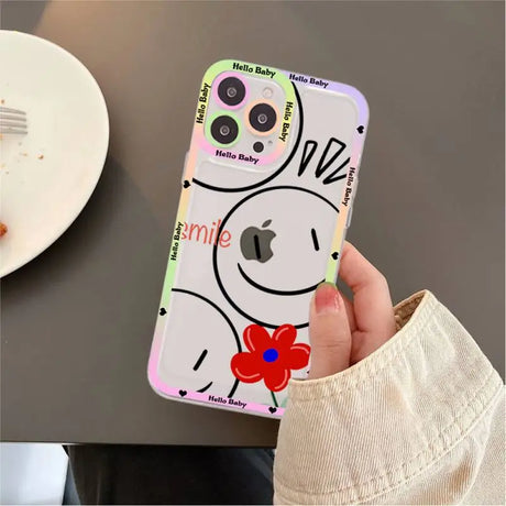 A person holding a phone case with a cartoon face