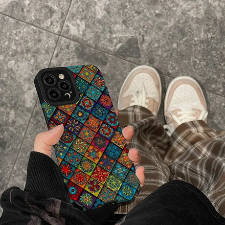 A person holding a phone case with colorful flowers on it