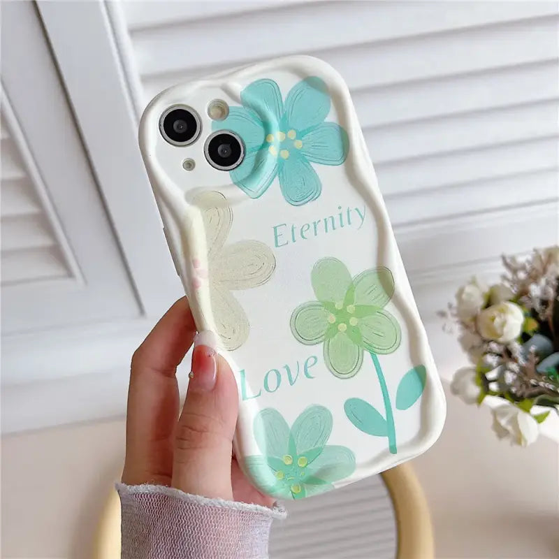 A person holding a phone case with flowers on it