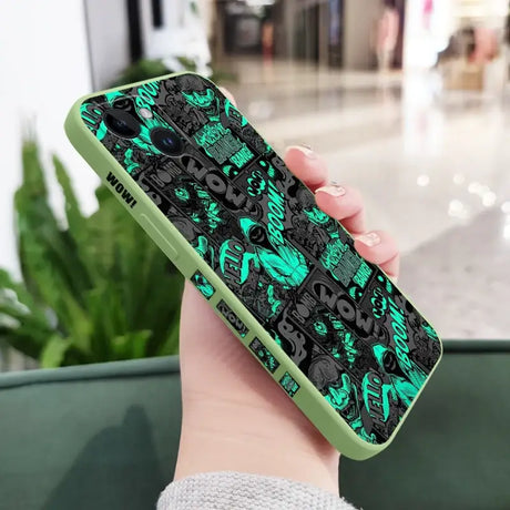 A person holding a phone case with a green and black pattern