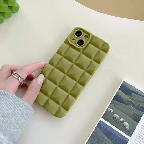 A person holding a phone case with a green cover