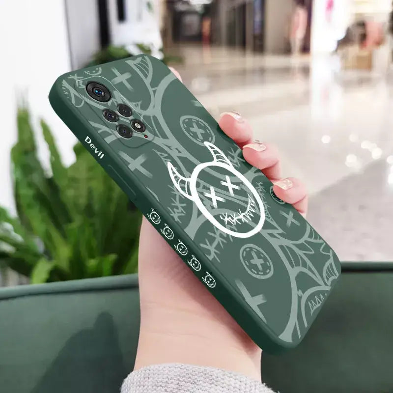 a person holding a phone case with a green and white design