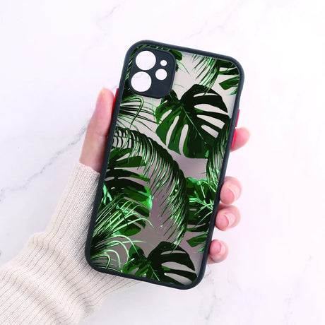 A person holding a phone case with green leaves on it