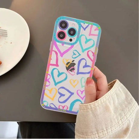 A person holding a phone case with hearts on it