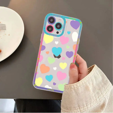 A person holding a phone case with hearts on it