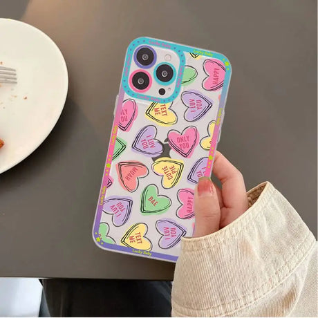 A person holding a phone case with hearts on it