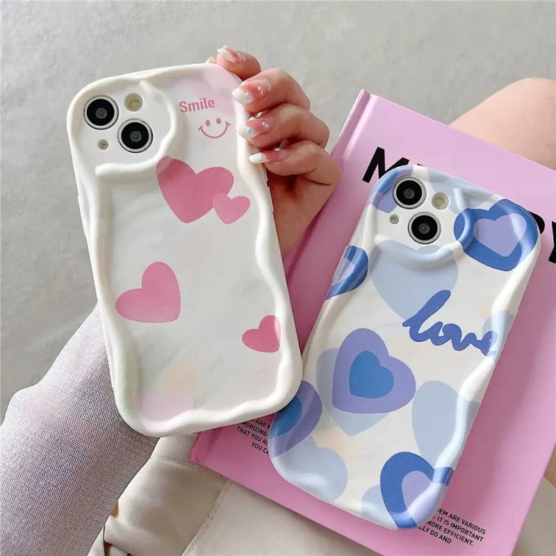 a person holding a phone case with hearts on it