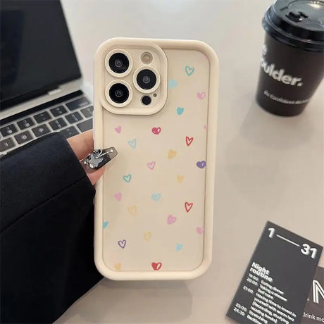 a person holding a phone case with hearts on it