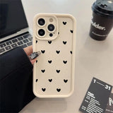 a person holding a phone case with hearts on it