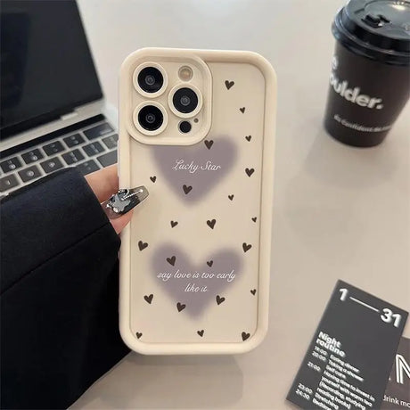 a person holding a phone case with hearts on it