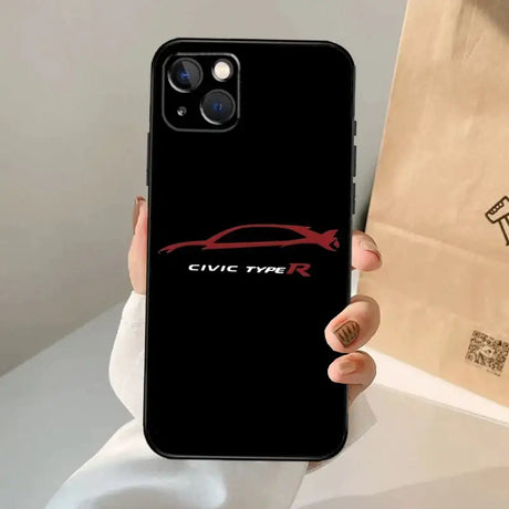 A person holding a phone case with the logo of a car